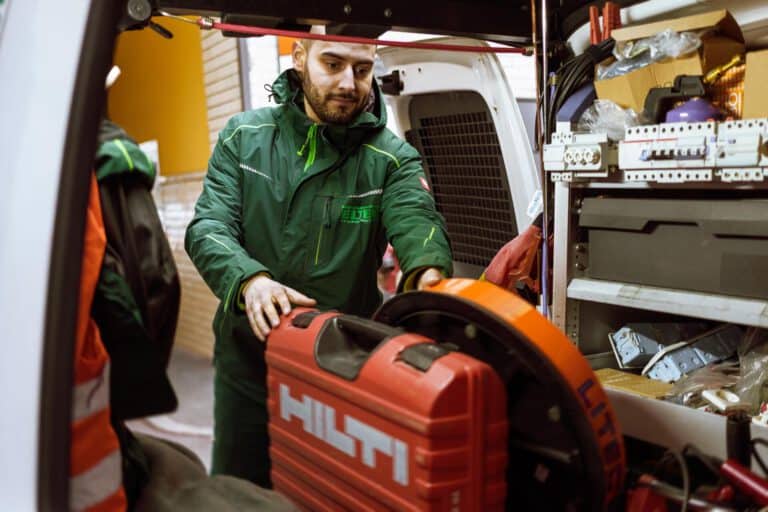 Beladen des Werkstattwagens Mitarbeiter beim Beladen im Unternehmensumfeld, authentische Darstellung logistischer Arbeitsprozesse und Teamarbeit