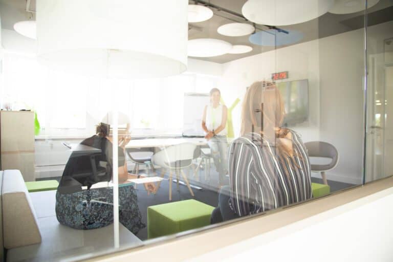 Corporatefotografie Hamburg – Teambesprechung im Konferenzraum Corporate-Fotografie Hamburg – Geschäftsteam in Besprechung hinter Glaswand in modernem Konferenzraum mit Urban-Look