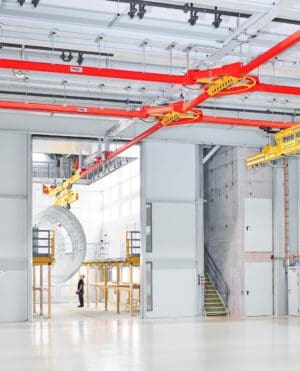 Industriefotografie Flugzeugbau Transport Bauteile Mitarbeiter transportieren große Flugzeugbauteile mit Spezialgerät in einer Werkhalle – präzise Industriefotografie Luftfahrt- und Maschinenbau.