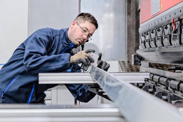 Industriefotografie Handwerk und Ladenbau Bremen Handwerker montiert präzise Metallkonstruktion im modernen Ladenbau – authentische Industriefotografie für Handwerk und Produktion in Norddeutschland.