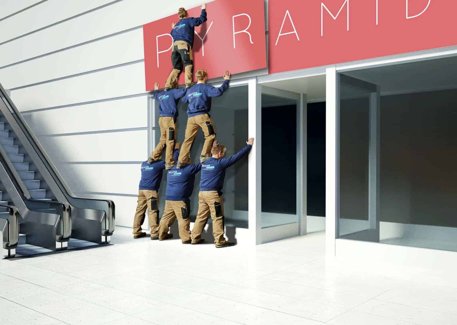 Werbefoto Composing Menschenpyramide um ein Schild aufzuhängen