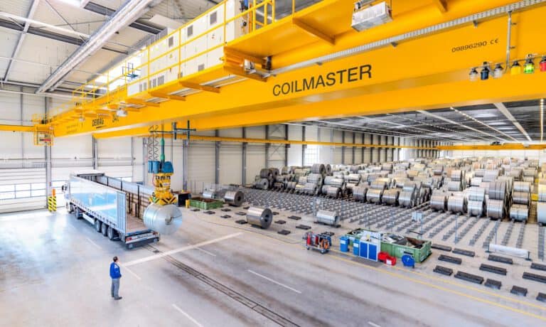 LKW-Beladung mit Stahl – Industriefotografie Logistik Kran belädt einen LKW mit Stahlrollen – Logistik in der Industrie