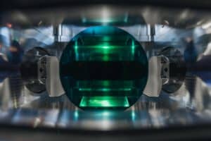 Innenansicht einer Anlage, in der eine grüne Platine bearbeitet wird.