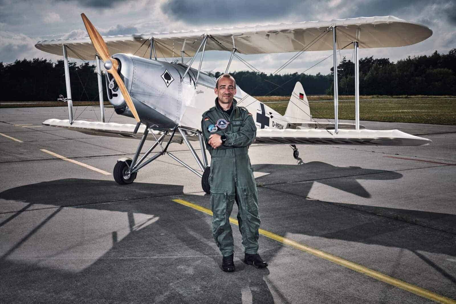 Foto eines Piloten vor seinem Doppeldecker
