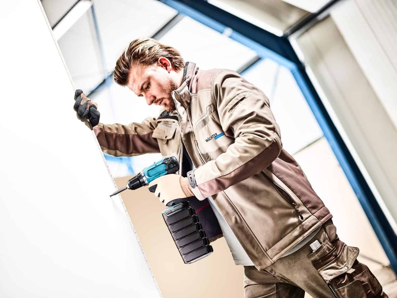 Werbefoto Composing ein Handwerker mit Akkuschrauber und übergroßem Akku