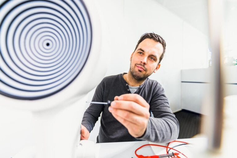 unternehmensdarstellung-fotografie-mitarbeiter-werkstatt Corporate Fotografie in der Produktion, ein Monteur schraubt an einer Maschine